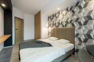 1 dormitorio con 1 cama grande y pared geométrica en Super-Apartamenty Luxury, en Poznan
