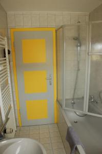 a bathroom with a shower and a yellow door at DaMIsa House in Metzingen