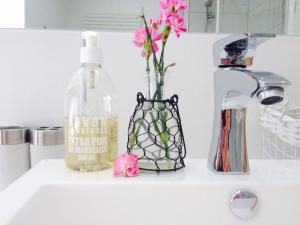 a vase filled with pink flowers sitting on a sink at Bed and Breakfast 57 in Asuel +37 photos