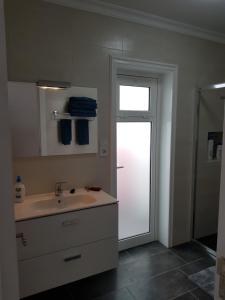 a bathroom with a sink and a sliding glass door at Apartamentos Capellania in Puerto del Carmen +35 photos