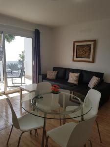 a living room with a glass table and a couch at Apartamentos Capellania in Puerto del Carmen