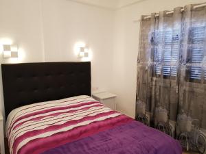a bedroom with a bed and a window with curtains at Apartamentos Capellania in Puerto del Carmen