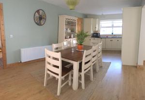 una cucina e una sala da pranzo con tavolo e sedie di No 4 Ballymastoker Cottage a Portsalon