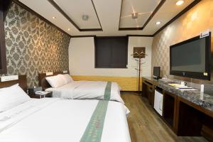 Un pat sau paturi într-o cameră la Suncheon Nobless Hotel