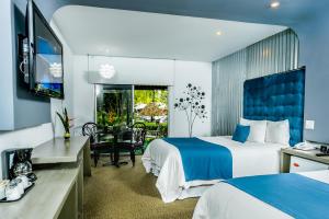 ein Hotelzimmer mit zwei Betten und einem Fernseher in der Unterkunft Riande Aeropuerto Hotel Casino in Tocumen