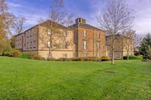 a large brick building on a green field at The View Deer Park Luxury Apartment in Edinburgh