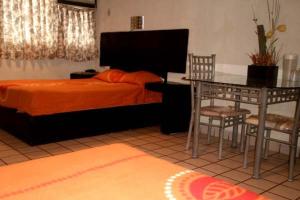 1 dormitorio con 1 cama, mesa y sillas en Hotel Miramar - La Paz, en La Paz