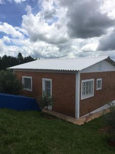 a red brick building with a white roof at Vila Formosa Rural in São Pedro