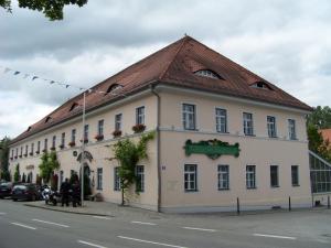 a large white building with a brown roof at Hotel Landgasthof Zur Post in Mengkofen