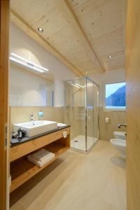 bagno con lavandino, doccia e servizi igienici di Garni August a Ortisei