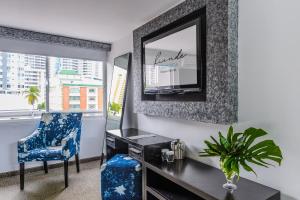 um quarto com uma secretária, uma cadeira e um espelho em Riande Urban Hotel na Cidade do Panamá