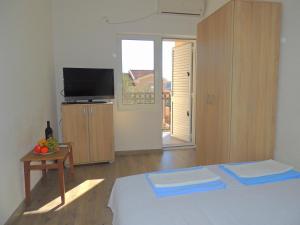 a bedroom with a bed and a television and a table at Guest House Jelena in Budva