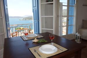 stolik z dwoma kieliszkami wina i widokiem na ocean w obiekcie Panoramic View w Poros