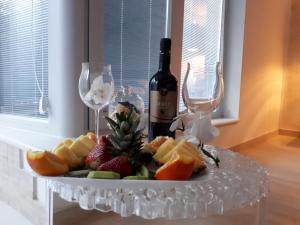 un piatto di frutta con una bottiglia di vino e bicchieri di OLYMPUS PARK amnesia a Mesagne Altre 9 foto