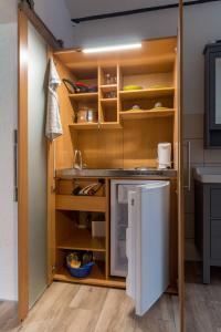 a kitchen with a white refrigerator and wooden shelves at Gästezimmer in Manschnow