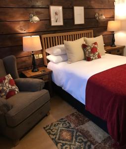 a bedroom with a bed and a chair and a couch at Boutique Garden Lodge @ The Larches in Wolverhampton