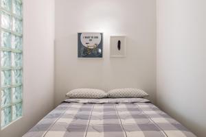 ミラノにあるFan House 22のベッド1台(壁に時計付)