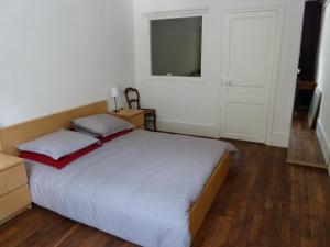 Un dormitorio con una cama grande y una ventana en Les Carrés en Versailles