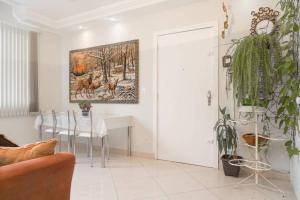 a living room with a table and a painting on the wall at HomeStay 2 - Avenida Carlos Gomes in Porto Alegre