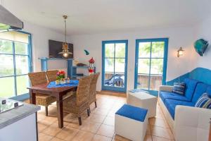 a living room with a blue couch and a table at Ferienwohnung Rügen-Freiheit in Putgarten