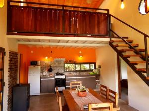 Mágico Atardecer Cabaña في تونويان: مطبخ وغرفة طعام مع درج في المنزل