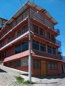 un bâtiment rouge avec un pôle devant lui dans l'établissement Casa Xelaju Apartments, à Quetzaltenango