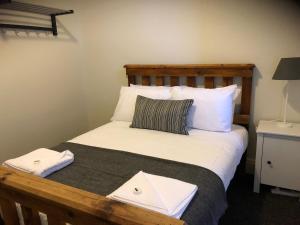 
a white bed with a white comforter and pillows at Cornwall Hotel in Moonta
