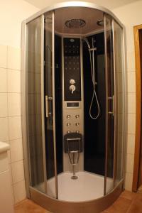 a glass shower in a bathroom with a mixer at Karawankenpanorama 1. OG in Grassendorf