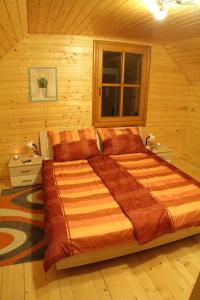 a bedroom with a large bed in a wooden room at Karawankenpanorama 1. OG in Grassendorf