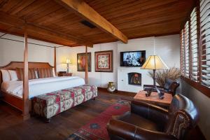 a bedroom with a bed and a desk and a chair at The Hermosa Inn in Phoenix