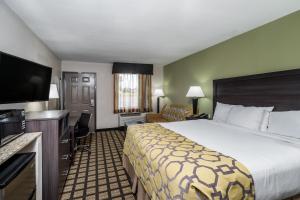 Baymont by Wyndham Clarksville في كلاركسفيل: غرفة فندقية بسرير وتلفزيون بشاشة مسطحة