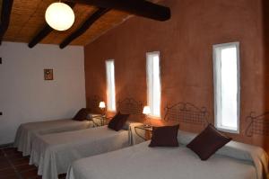 a room with four beds in a room with windows at Finca El Carmen Cabañas in Angastaco +22 photos