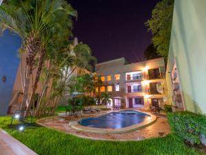 a swimming pool in front of a building at night at Hotel del Gobernador in Mérida