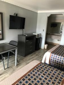 a hotel room with two beds and a desk and a television at SouthTown S.A. Inn in San Antonio