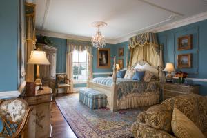 ein Schlafzimmer mit blauen Wänden und einem Bett und einem Sofa in der Unterkunft The Chanler at Cliff Walk in Newport