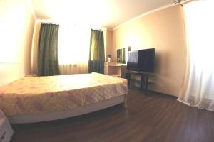 a bedroom with a bed and a flat screen tv at Studio in the center VLKSM 13 in Tyumen