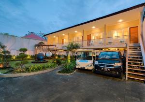 two vans parked in a parking lot in front of a house at Destiny Villas and Residence in Seminyak