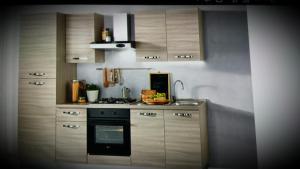 a kitchen with wooden cabinets and a stove top oven at Alessi Suites & Studio in Mazzarino