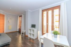 a living room with a white table and a television at BET Apartments - Tramontana Apartments in Valencia