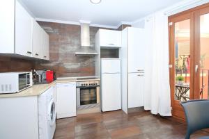 a kitchen with white appliances and a balcony at BET Apartments - Tramontana Apartments in Valencia