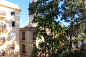 a tree in front of a building with a tower at BET Apartments - Tramontana Apartments in Valencia