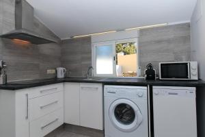 a kitchen with a washing machine and a microwave at BET Apartments - Tramontana Apartments in Valencia
