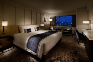 a hotel room with a large bed and a desk at Grand Prince Hotel Takanawa in Tokyo