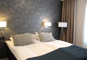 una camera da letto con un letto con due lampade sopra di Hotell Rättvik a Rättvik