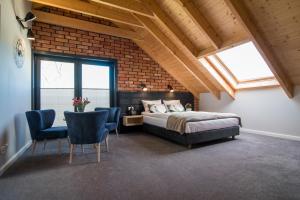 a bedroom with a bed and chairs and a brick wall at U przyjaciol - Debki in Dębki