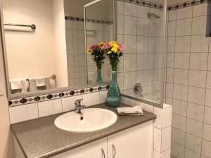 
a white sink sitting under a mirror in a bathroom at Little Shangri-La B&B in Busselton

