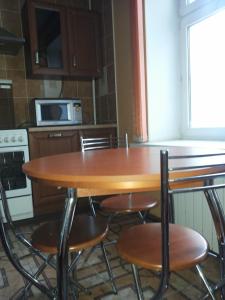 a kitchen with a wooden table and chairs at Apartments on Kommunisticheskaya 25 in Saransk