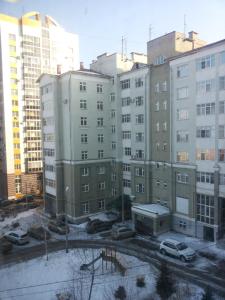 a group of buildings with cars parked in a parking lot at Apartments on Kommunisticheskaya 25 in Saransk