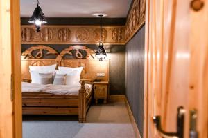 sypialnia z łóżkiem z drewnianym zagłówkiem w obiekcie Bajka Resort & GARDEN SPA w mieście Grodziec