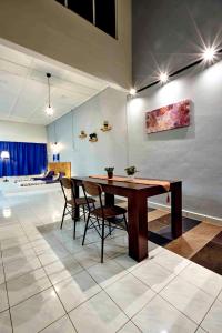 a dining room with a wooden table and chairs at Home Art 103 in Ipoh